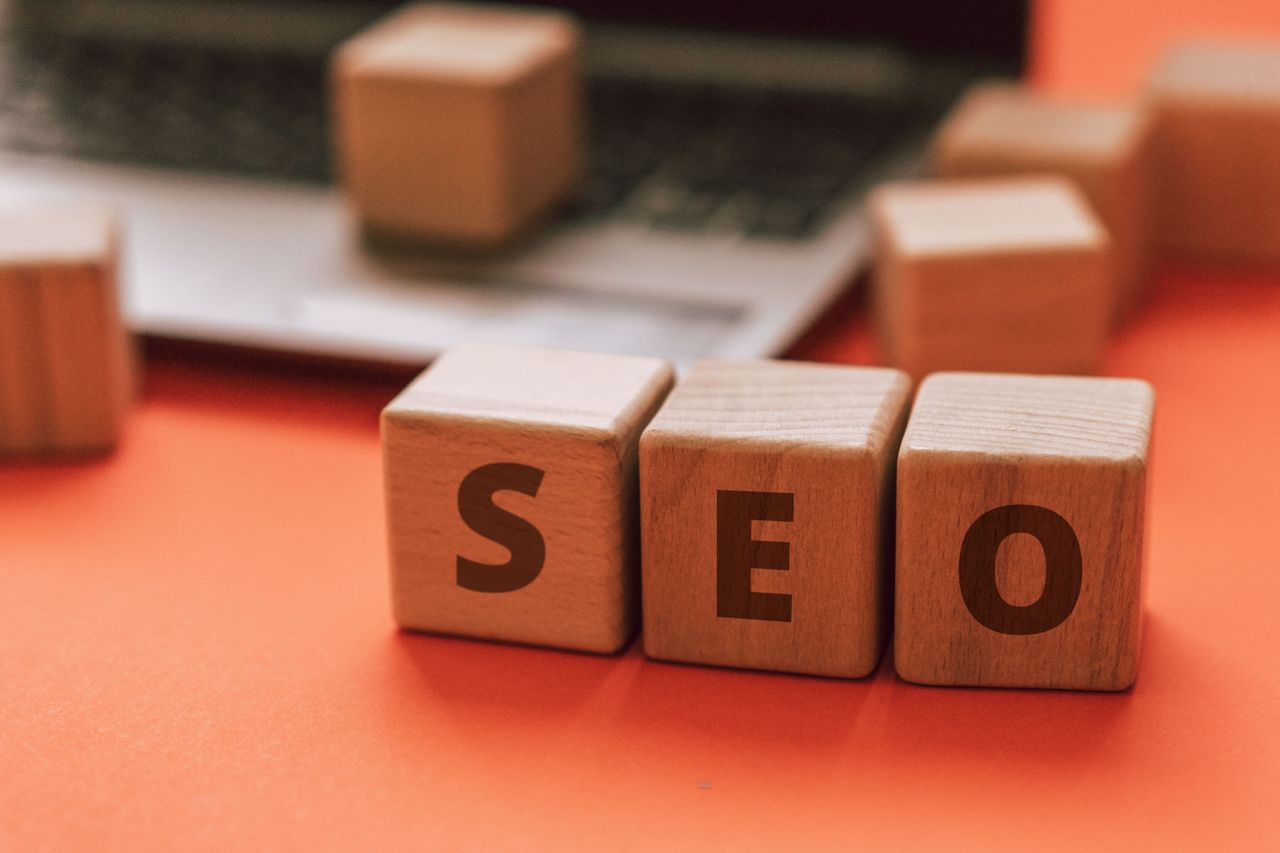 who-we-are Wooden blocks spelling SEO on a laptop keyboard convey digital marketing concepts.